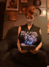 a woman sitting on a couch wearing a black shirt that says bliss rays