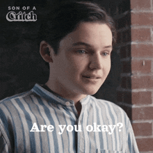 a young man in a striped shirt is asking if he is okay