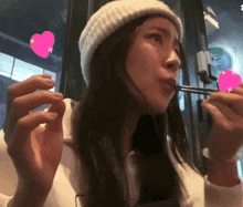 a woman wearing a white hat eating with chopsticks