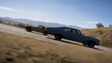 a blue car is driving down a road next to another car