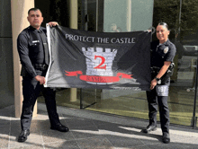 two police officers holding up a flag that says protect the castle
