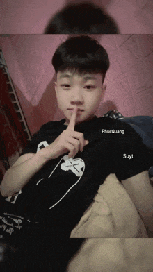a young boy with a black shirt that says phụcquang suyt on it