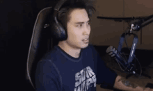 a man wearing headphones and a shirt that says star wars