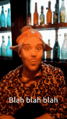a man wearing an orange hat and a leopard print shirt says blah blah blah .