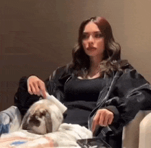 a woman is sitting on a couch holding a rabbit .