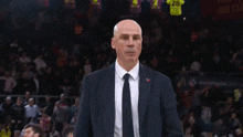 a man in a suit and tie is walking in a dark room