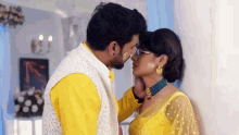 a man and a woman are kissing each other in a room .