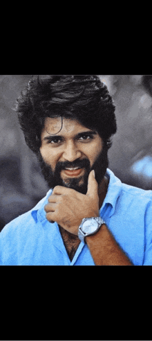 a man with a beard is wearing a watch on his wrist