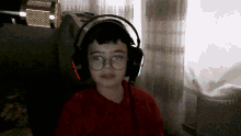 a young boy wearing headphones and glasses is looking at the camera