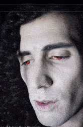 a close up of a man 's face with a red eye
