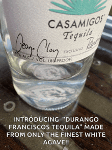 a bottle of casamigos tequila sits on a wooden table