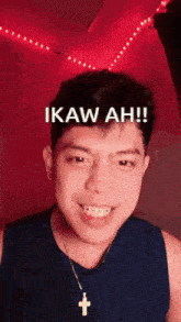 a man wearing a cross necklace is smiling and says ikaw ah