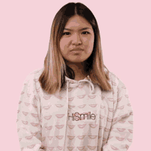 a woman wearing a hoodie that says hismile is making a funny face