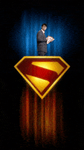 a man in a suit and tie stands on top of a superman logo