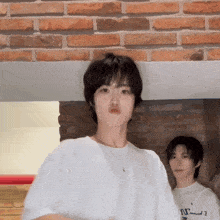 a man wearing a white shirt that says nirvana is standing next to another man