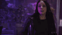 a woman stands in a dark room with a purple light behind her and the words ctv on the bottom right