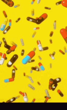 a bunch of pills are falling on a yellow background .