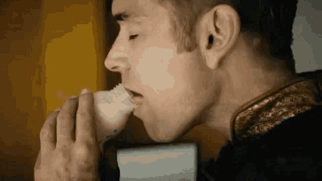a man is drinking milk from a bottle with a spoon in his mouth .