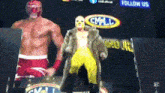 two wrestlers are standing in front of a cmll sign