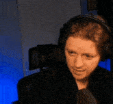a woman is wearing headphones and smiling while looking at the camera .