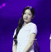 a woman in a white shirt is standing in front of a purple background with the words ( c ) no.watermark visible