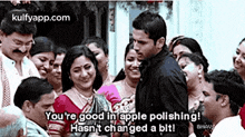 a man is standing in front of a group of people and says `` you 're good in apple polishing ! ''