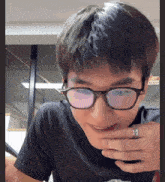 a man wearing glasses and a ring with a chinese symbol on it