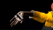a person wearing a yellow jacket is holding a red object