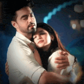 a man and a woman are hugging each other with their eyes closed