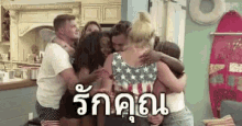 a group of people are hugging each other in a room with a surfboard hanging on the wall .