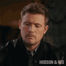 a close up of a man 's face with the words hudson & rex on the bottom right