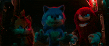 sonic the hedgehog and knuckles are standing next to each other in the dark .