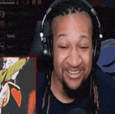 a man wearing headphones is smiling while watching a video