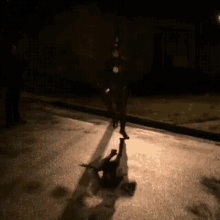 a man in a superhero costume is walking down the street at night