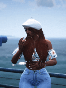 a woman wearing a white beret and a floral top stands on a pier overlooking the ocean
