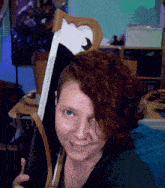 a woman with red hair and a nose ring holds a sword