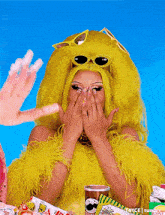 a woman in a yellow wig and sunglasses covering her face