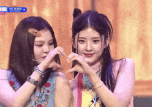 two girls are making a heart shape with their hands in front of a screen that says kill me boss
