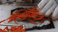 a person is making a sushi roll with carrots and seaweed and the words made in animotica on the bottom