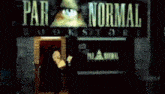 a man stands in front of a paranormal book store