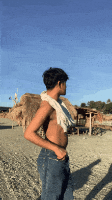 a man without a shirt is standing on the beach