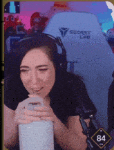 a woman is wearing headphones and a secret lab chair