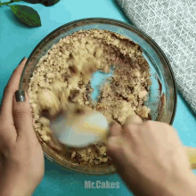 a person is mixing nuts in a glass bowl with the words mr.cakes written on the bottom