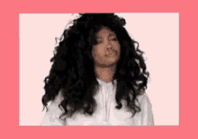 a woman with curly hair is wearing a white hoodie .