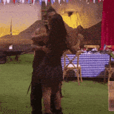 a man and woman are hugging in front of a table