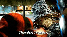 a man in armor is talking to another man in a striped hat .