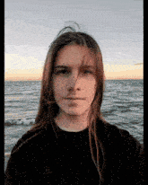 a young man with long hair is wearing a black champion sweatshirt