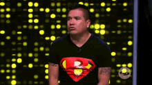 a man wearing a black shirt with a superman logo on his chest
