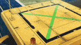 a yellow vehicle with a green x on the bottom