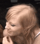 a woman with red hair is sitting in a car with a man and smiling .
